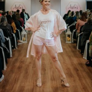 woman wearing personalised pj's. White vest top with the wording Mrs summer to be in sparkly rose gold text. Pink and white striped shorts
