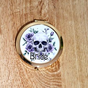 Metallic gold compact mirror featuring a skull and purple roses