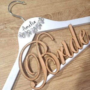 White wooden hanger with the name Amelia printed on in black and pearls below it. Also features a large wooden word 'Bride'.